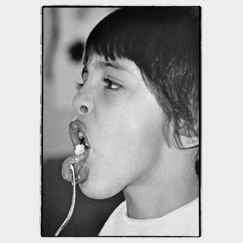 Young kid making a face while eating with fork