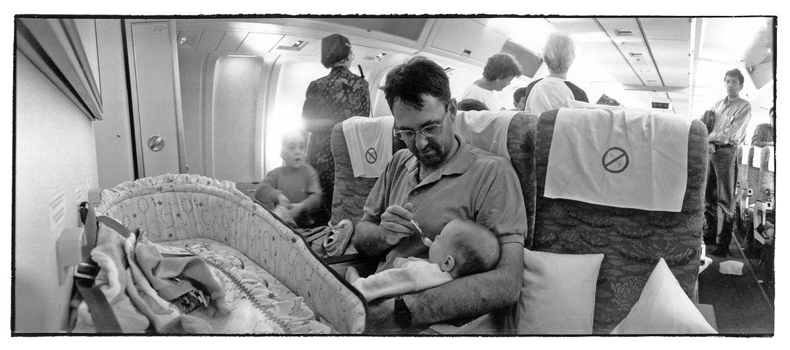 Man feeding his young son during a plane travel