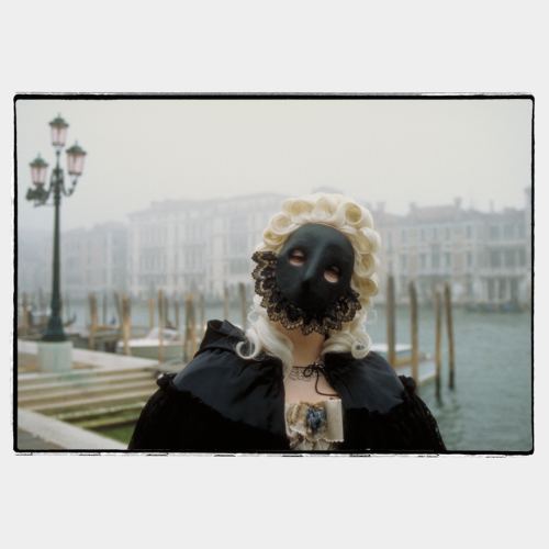 Venice Carnival: woma with black mask with fogged canal in the background